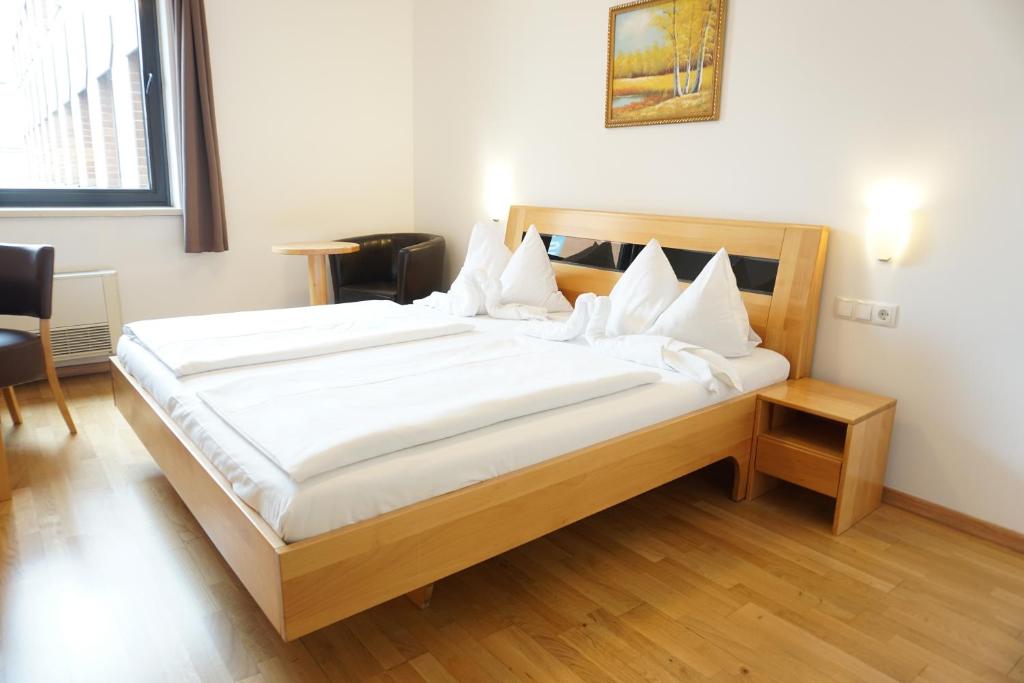 a bedroom with a large bed with white sheets at Hotel Kaffeemühle in Vienna