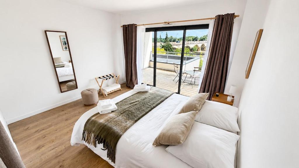 a bedroom with a large bed and a large window at Les Oiseaux de Loire in Les Ponts-de-Cé