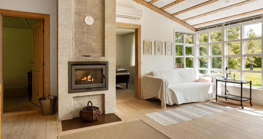 a living room with a fireplace and a white couch at Spacious Holiday Home With Large Plot By Buresø in Slangerup