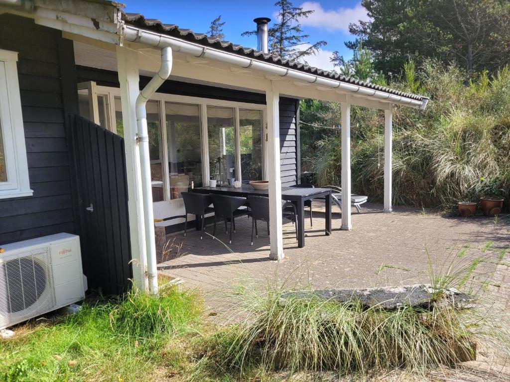 a screened in patio with a table and chairs at Natural Plot Fireplace And True West Coast in Thisted