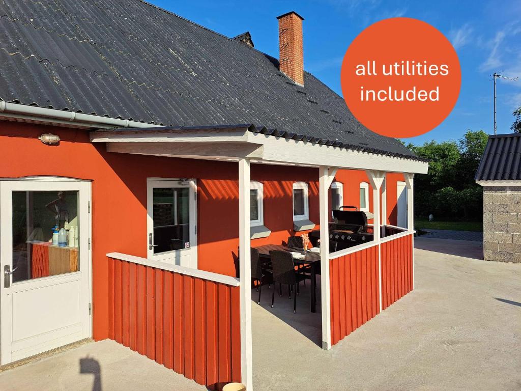 an orange house with a table in it with the words all utilities included at Idyllic Country Apartment Incl All Utilities in Christiansfeld