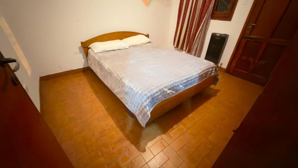 a bed in a room with a wooden floor at Dulce descanso 3 Bed and Breakfast in Salta