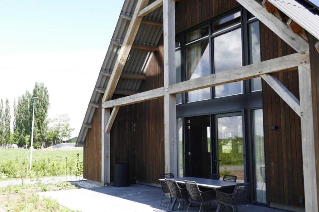a house with a table and chairs on a patio at Lennepserf - De Pinkels in Veessen