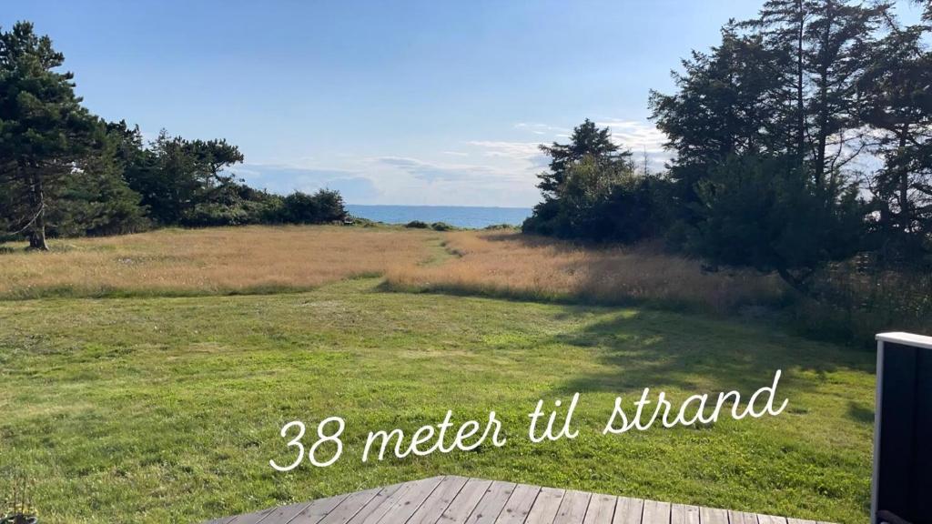a view of a field of grass with the words meter til stand at Summerhouse On The Beach And With Ocean View in Yderby