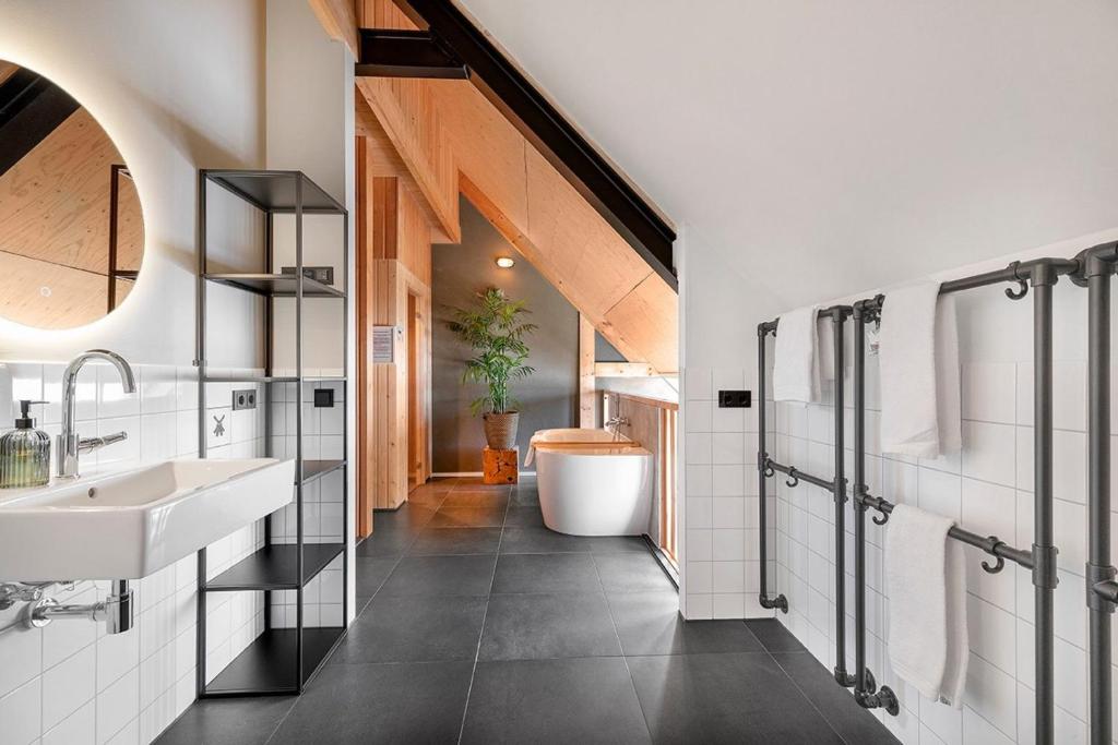 a bathroom with a sink and a tub at Lennepserf - De Achterhoek in Veessen