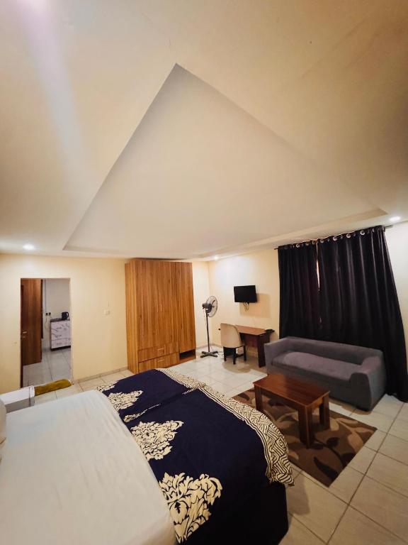 a bedroom with a bed and a couch and a table at Sea-Point Homes in Maiyegun