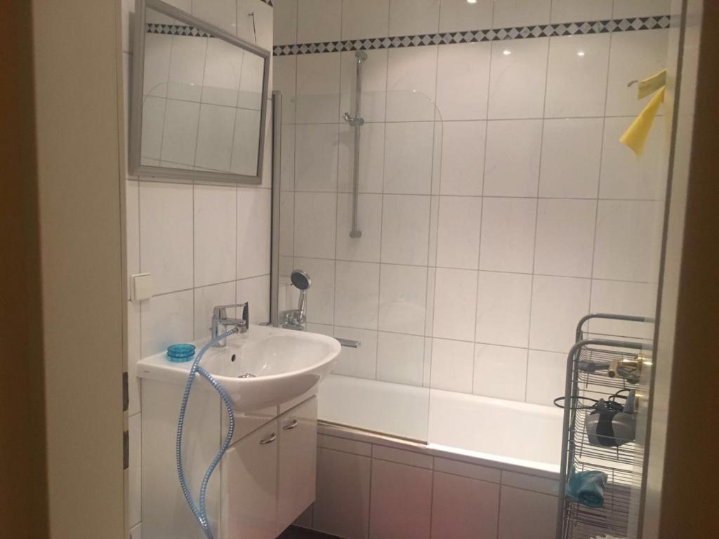 ein Badezimmer mit einem Waschbecken, einer Badewanne und einer Dusche in der Unterkunft Messezimmer Hannover Langenhagen - room agency in Hannover