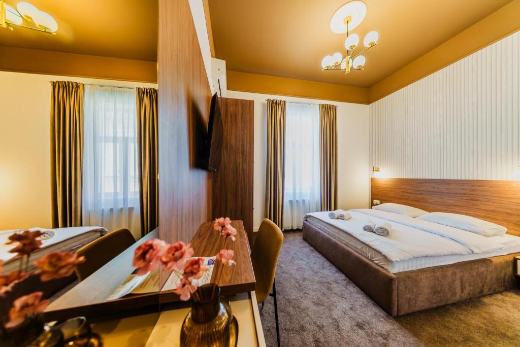 a hotel room with a bed and a table at BOUL ROSU RESIDENCE free private parking in Arad