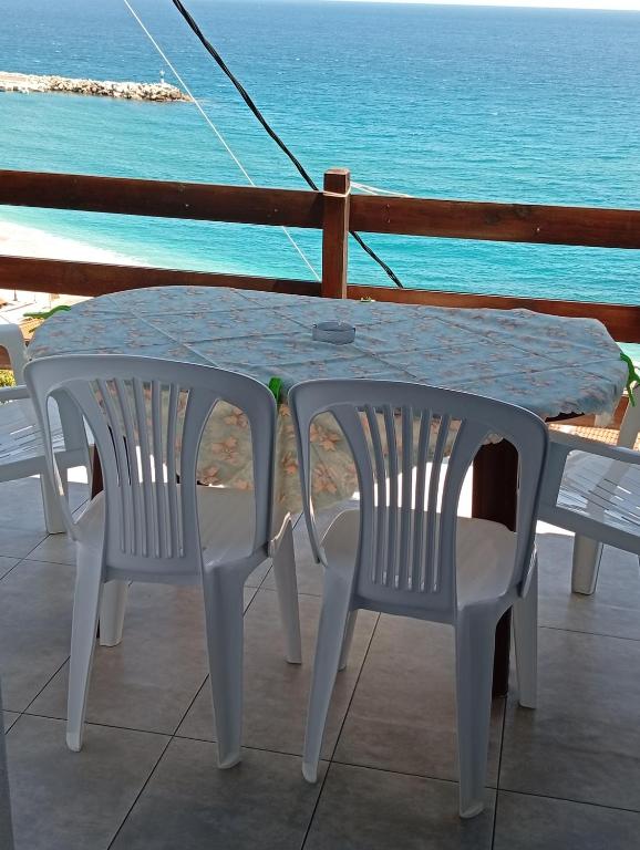 a table and chairs with a view of the ocean at Irida maria Family studios in Agios Ioannis Pelio