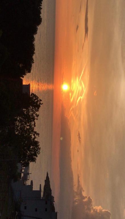 a sun setting in the sky over a city at Apartments Suljovic in Ulcinj