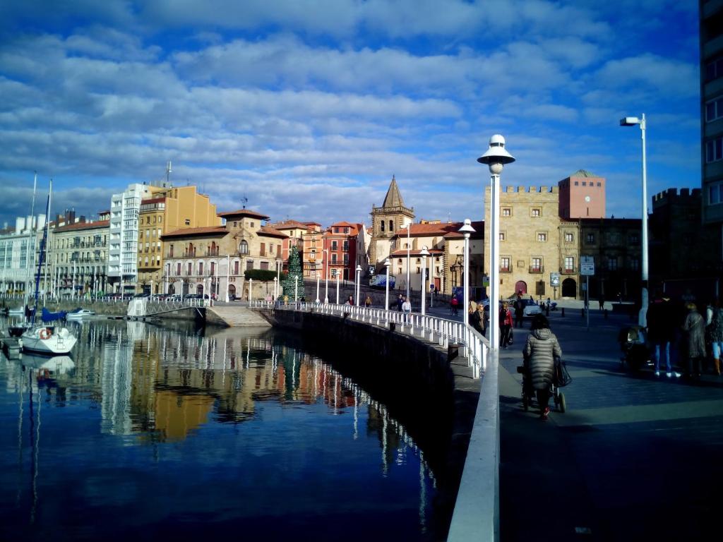 un puente sobre un río en una ciudad con edificios en Hotel Playa Poniente, en Gijón