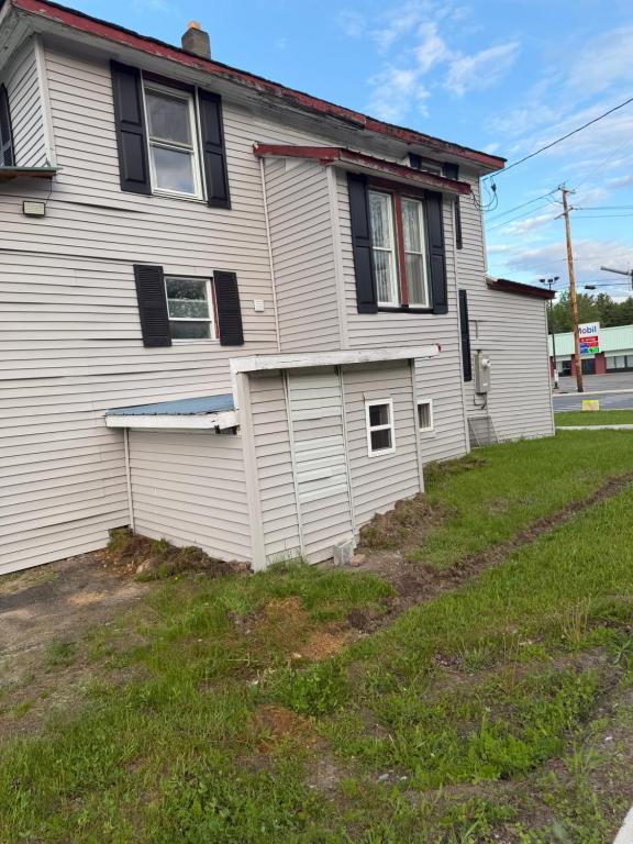 a white house with black windows and a yard at Plattsburgh Stay in Plattsburgh