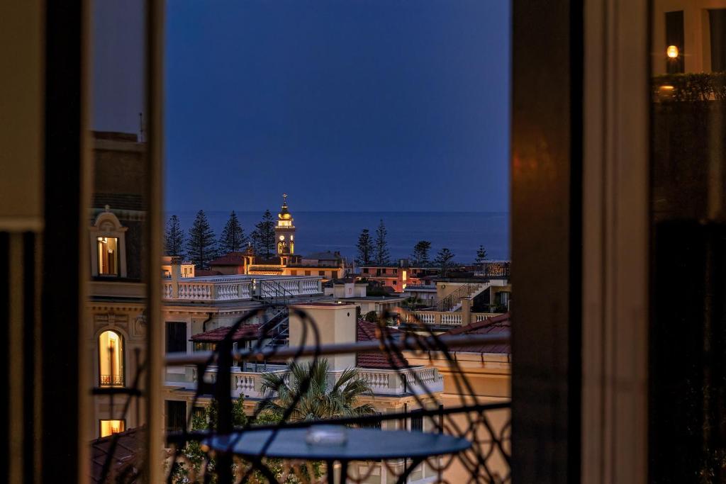 a view of a city at night from a balcony at Hotel Astoria in Bordighera