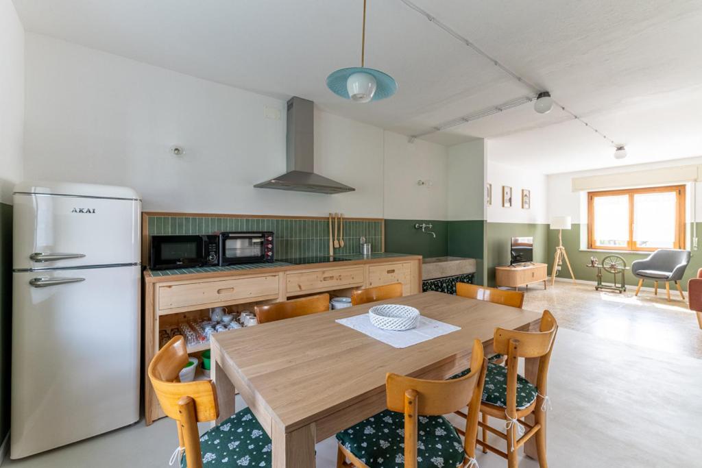 a kitchen with a wooden table and a refrigerator at Casa di Angelina in Avaglio