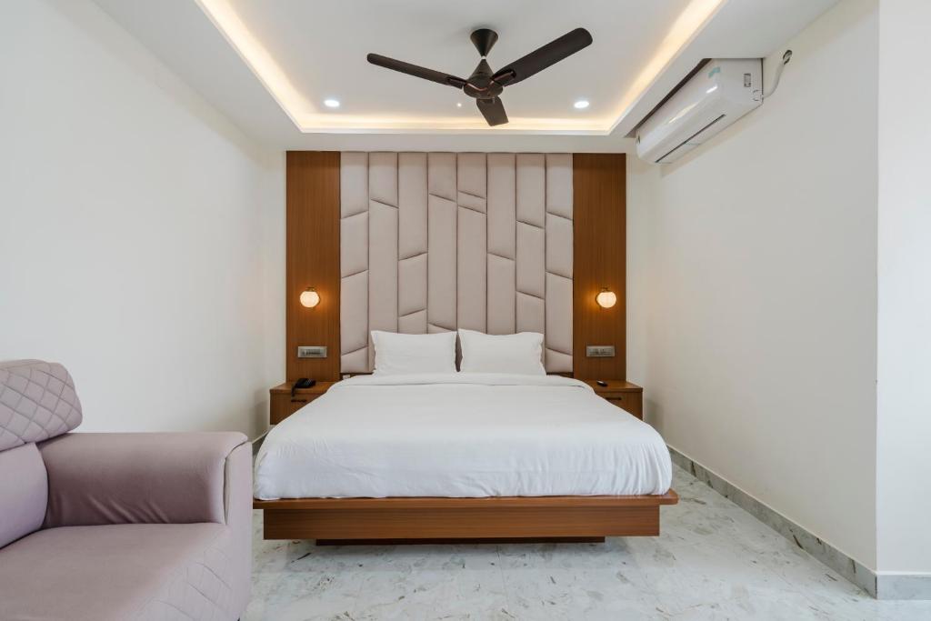 a bedroom with a bed and a ceiling fan at Hotel Rasballa Grand in Bhadrāchalam Road