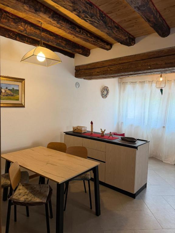 a kitchen with a table and a counter with a table and chairs at Cozy tiny flat in Cadore Dolomiti in Calalzo
