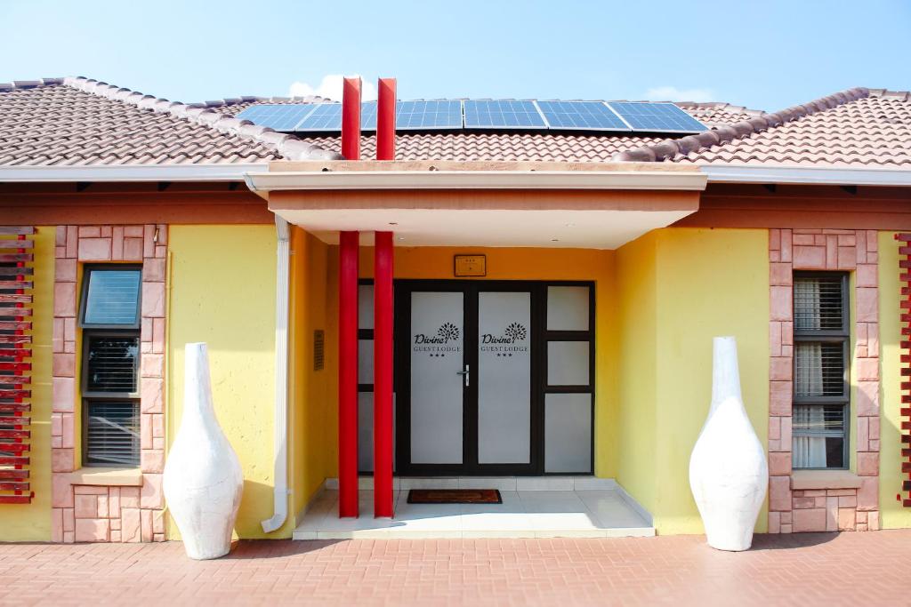 a house with two white vases in front of it at Divine Guest Lodge in Rustenburg