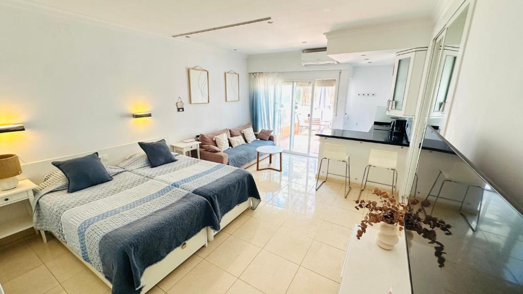 a bedroom with a bed and a living room at Hotel PYR, Spacious Studio with a Big Terrace in Fuengirola