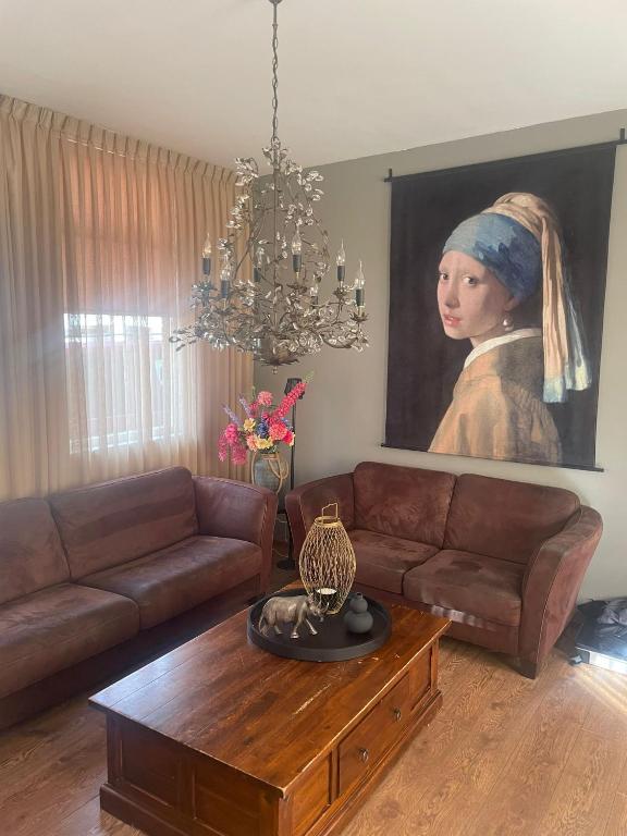 a living room with a couch and a painting of a woman at Oude Dorp Zicht in Urk