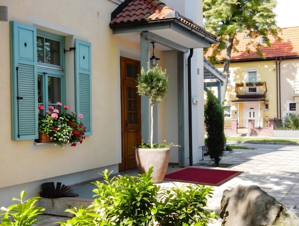 a house with blue shutters and flowers on the door at Villa Parma in Maribor Self check - in in Maribor