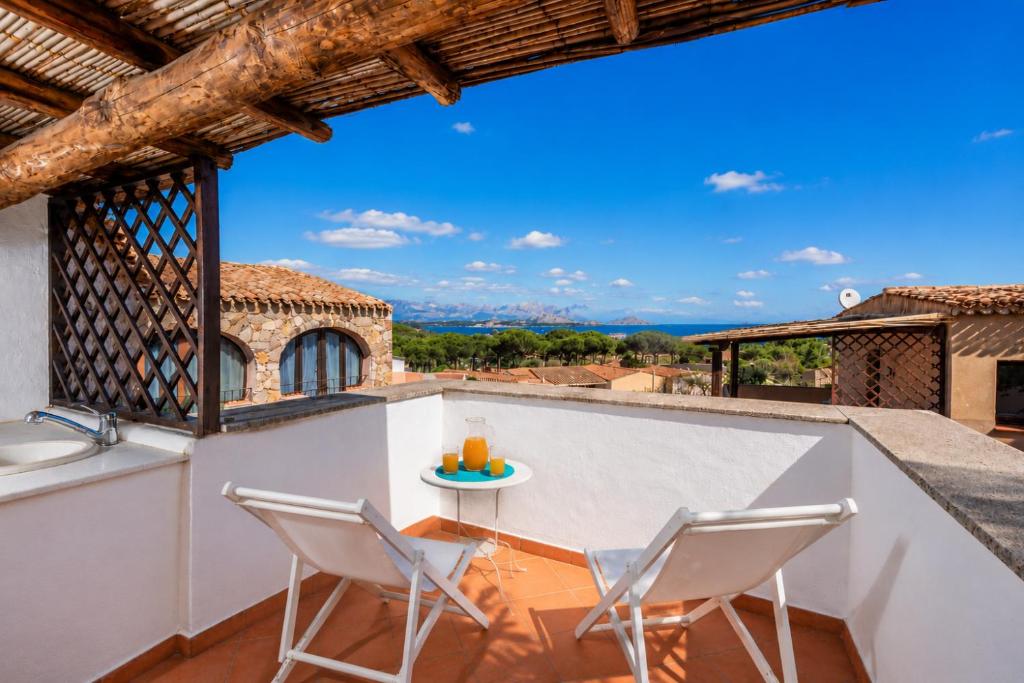 a patio with two chairs and a table on a balcony at Sea View Within Walking Distance of the Beach in Baja Sardinia