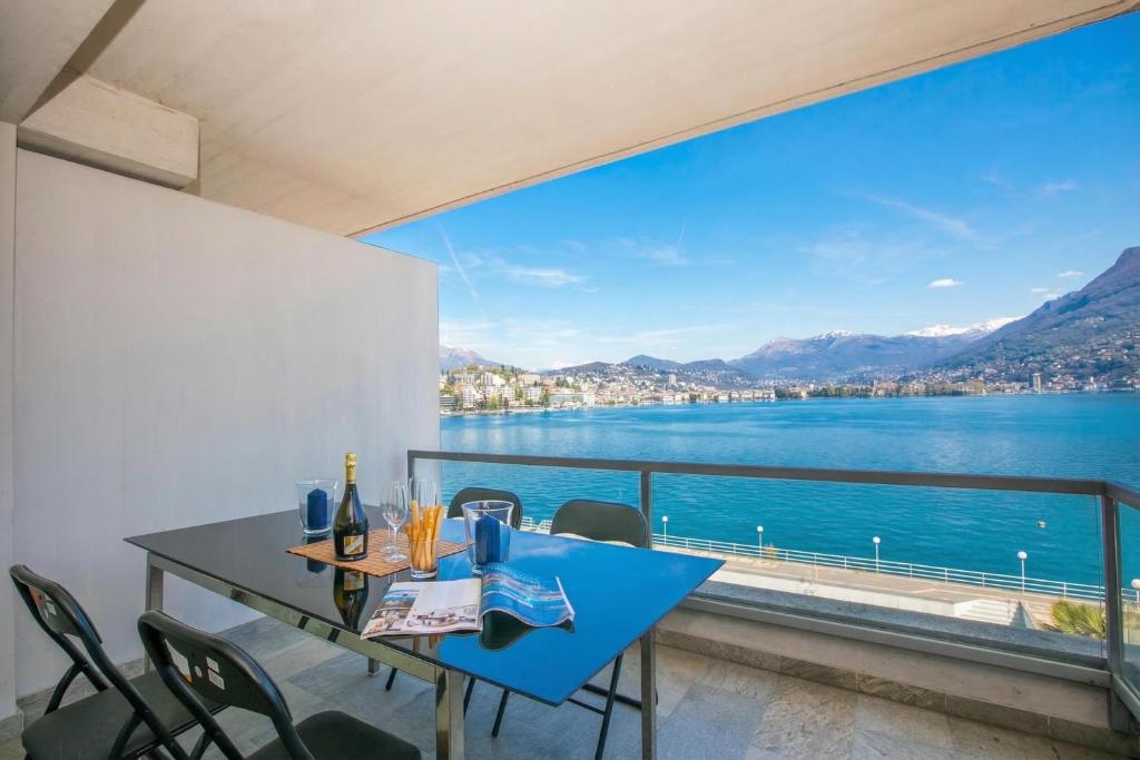 a dining room with a view of the water at Paradiso Incanto Lake View Apartment - Happy Rentals in Paradiso