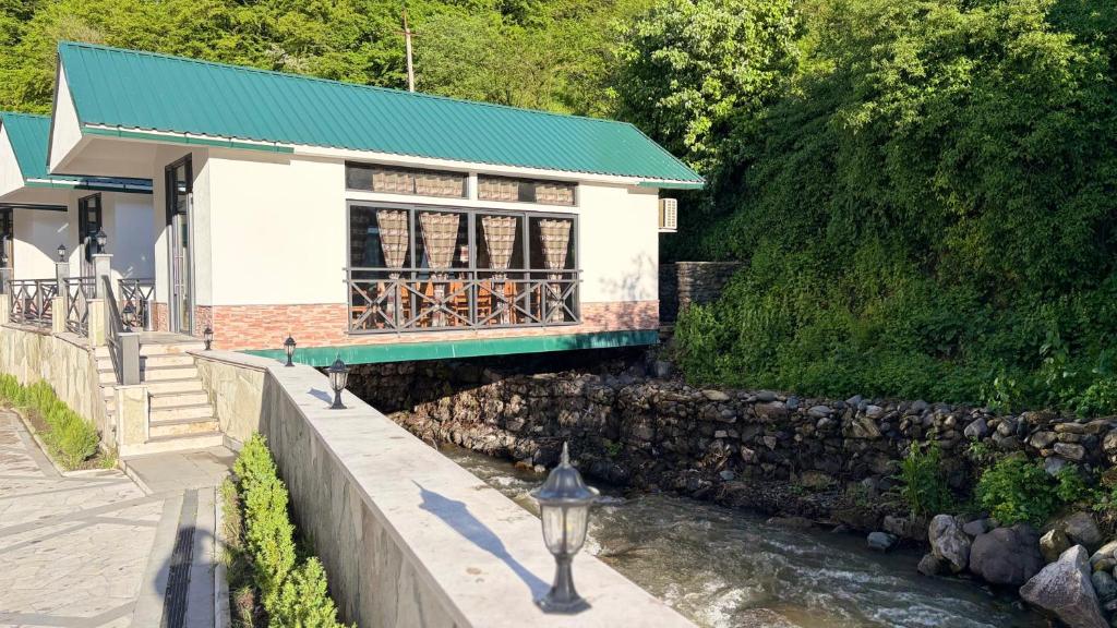 a building with a green roof next to a river at Harutyunyants Hall in Ijevan