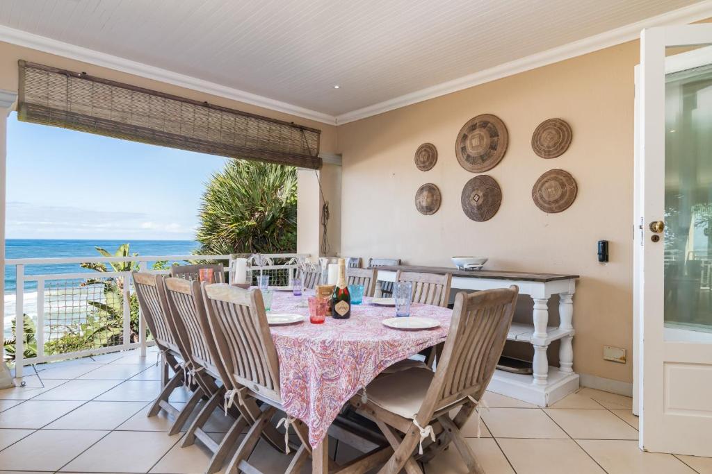 a dining room with a table and chairs and the ocean at Colwyn Drive 53 in Sheffield Beach