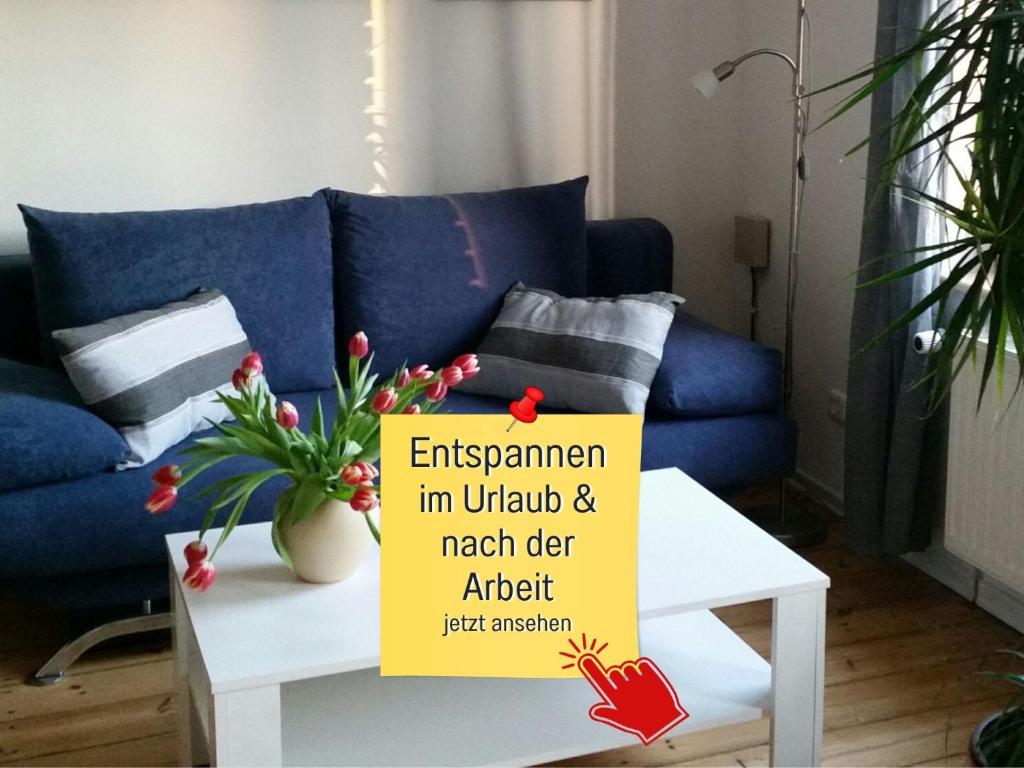 a living room with a blue couch and a sign on a table at Hof Heideland 1 in Eichholz