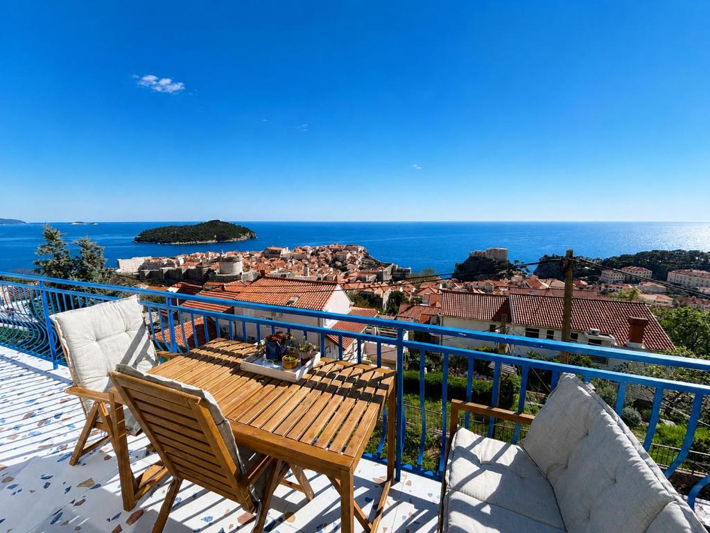 a balcony with a table and chairs and the ocean at Apartment Iris in Dubrovnik