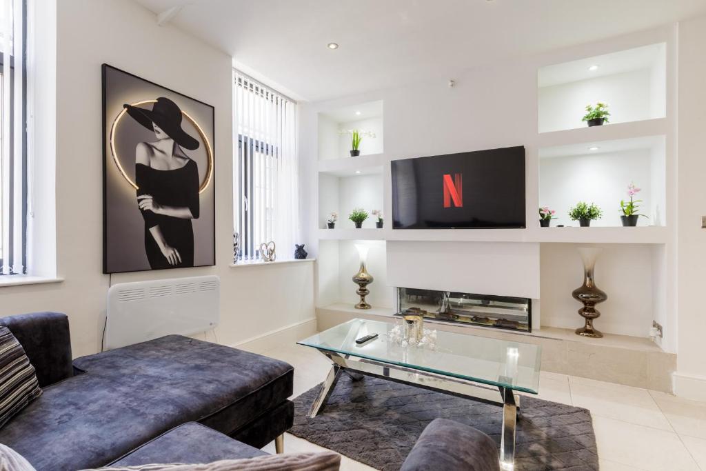 a living room with a couch and a tv at Bradford Chic City-Centre Apartment in Bradford