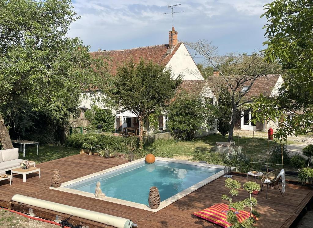 a backyard with a swimming pool and a house at La grange du Ruet in Saint-Hilaire-Saint-Mesmin
