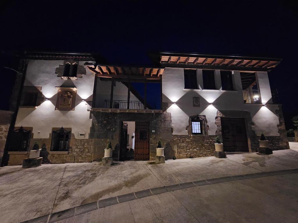 a large stone building with a lit up facade at night at CASA URRA in Zurucáin
