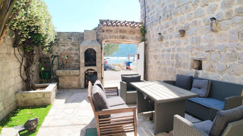 a patio with a table and chairs and a fireplace at Stone House Perast in Kotor