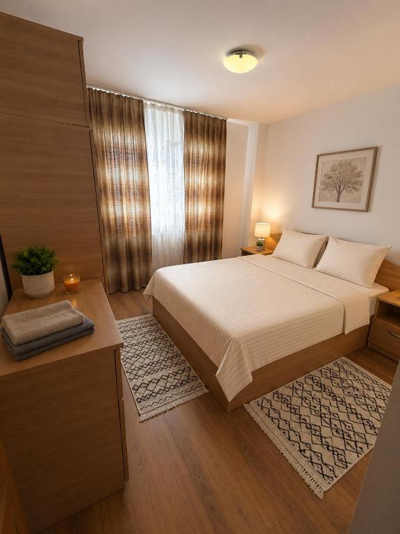 a bedroom with a large bed and a window at Apartament Central in Moineşti
