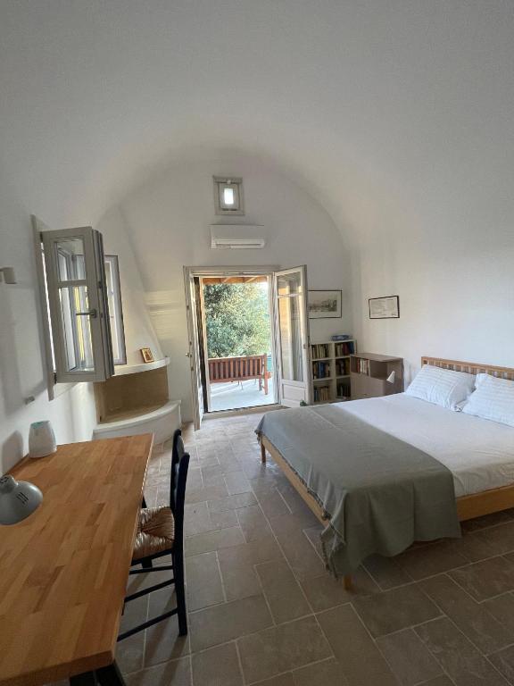 a bedroom with a bed and a table and a window at Studio Gaia in Kythira