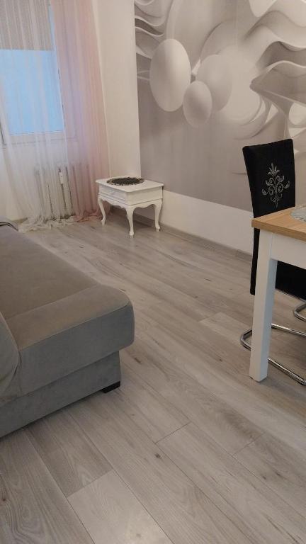 a living room with a couch and a table at Apartament u Amelki in Toruń