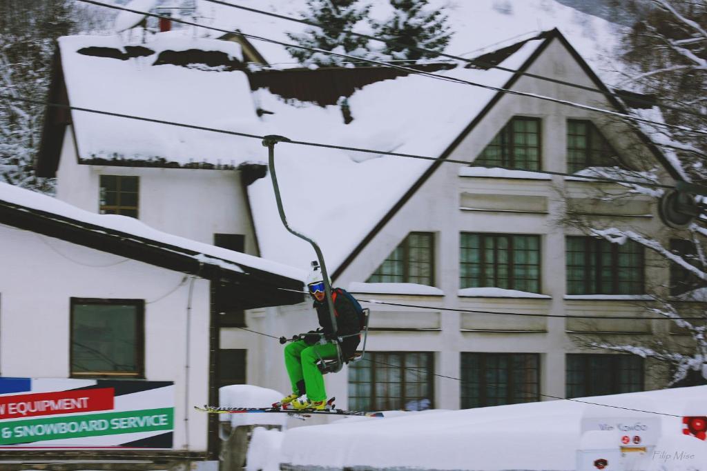 a person on a ski lift in front of a building at Hotel Fersped in Mavrovo
