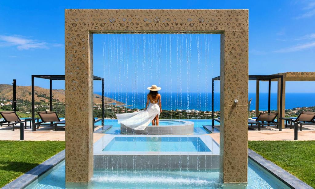 a woman in a white dress is standing in a fountain at Mistral Suite Heated Pool in Georgioupoli