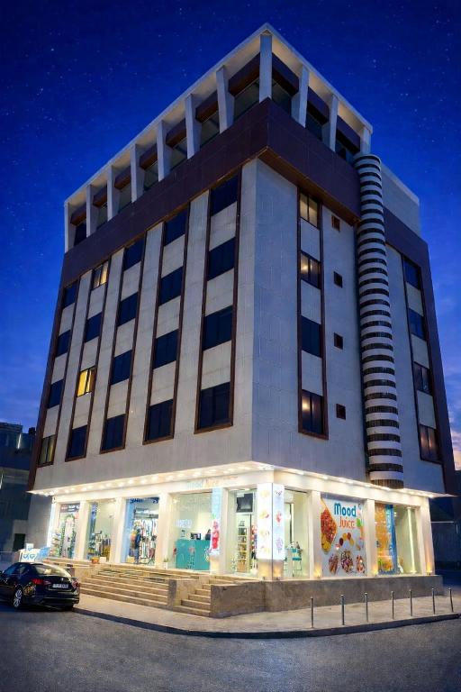 a building with a car parked in front of it at Rami Grand Residence in Erbil