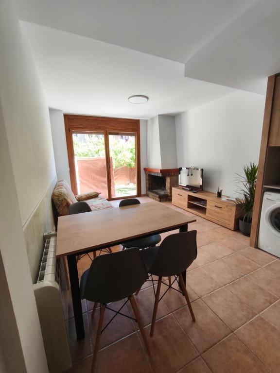 a living room with a wooden table and chairs at Apartament l'Adou in Bagá