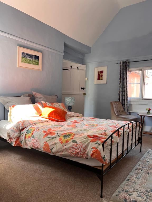 a bedroom with a bed and a chair at Flemish House in Beccles