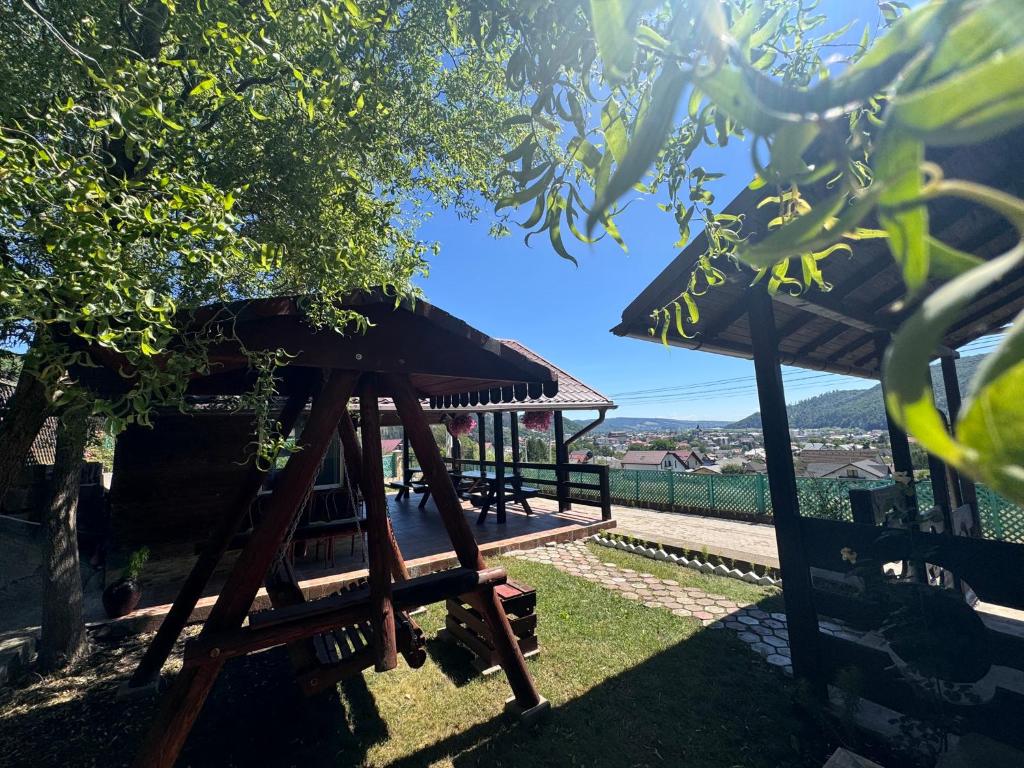 a gazebo with a roof on the grass at Casa Alexana in Gura Humorului