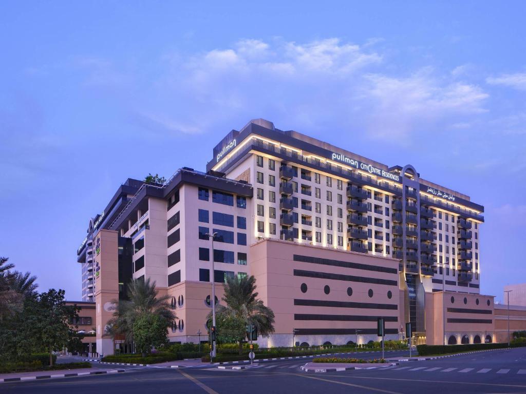 a large building with lights on top of it at Pullman Dubai Creek City Centre Residences in Dubai