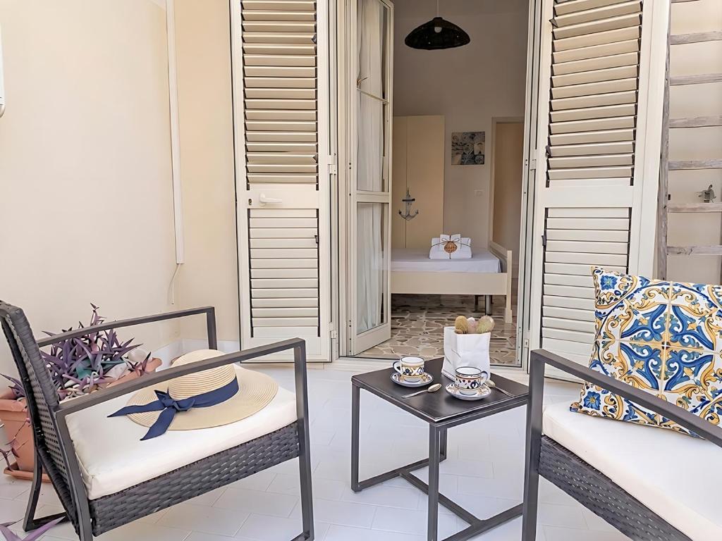 a patio with a chair and a table with a table at Libeccio House in Avola
