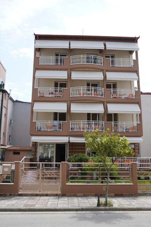 a building with balconies and a tree in front of it at Marie Claire Studios in Olympic Beach
