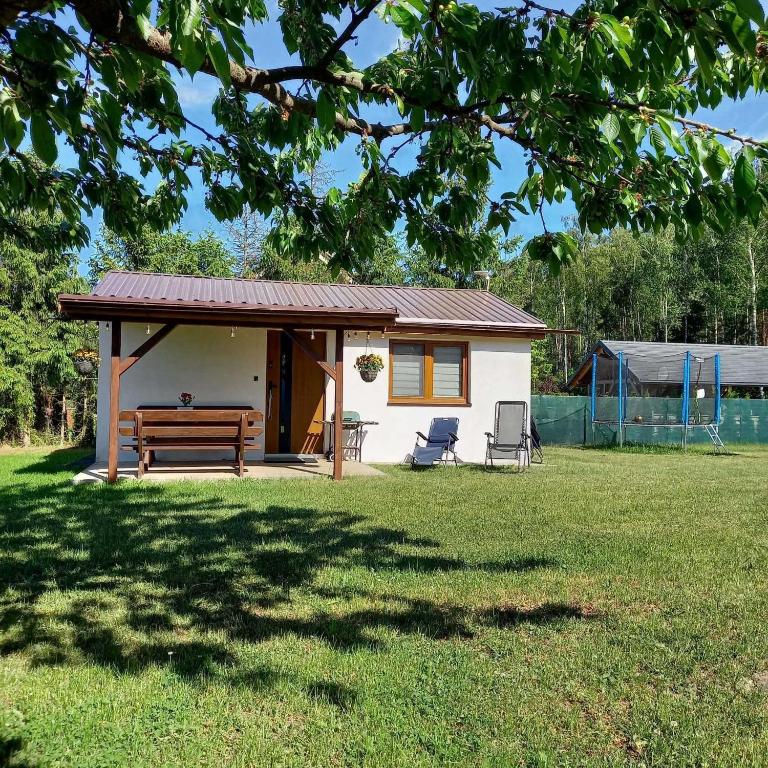 a small white house with a bench and a table at Ostoja Semlińska in Semlin