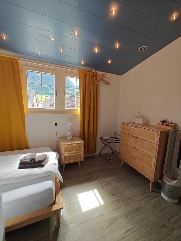 a bedroom with a bed and a dresser and a television at Hotel Freihof in Glarus