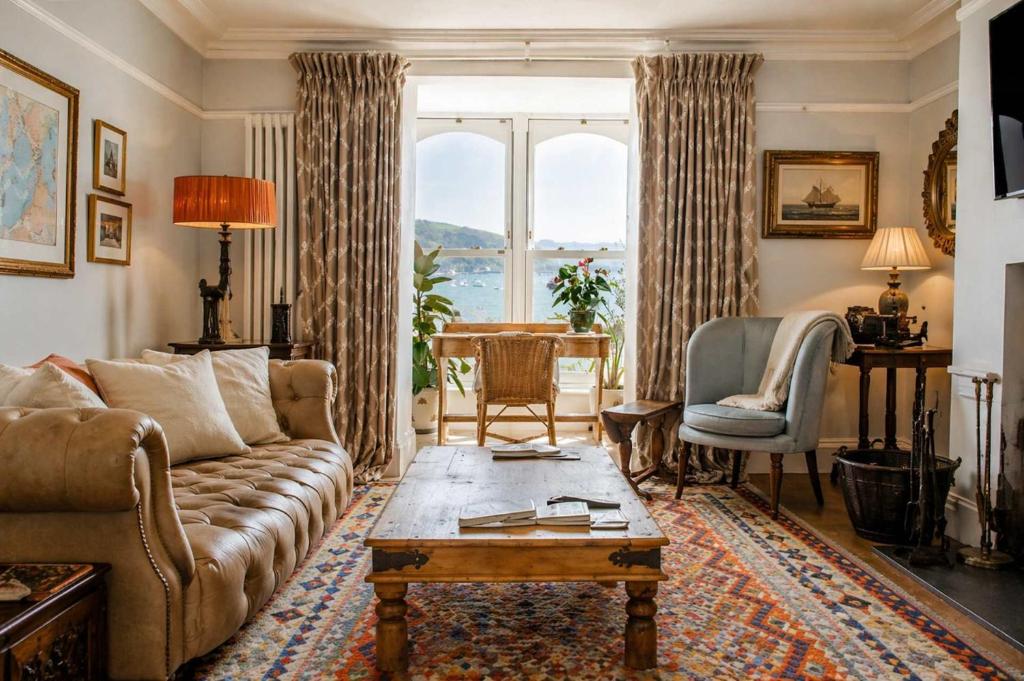 a living room with a couch and a table at Ty'n Porth - By Rowes Retreats in Falmouth