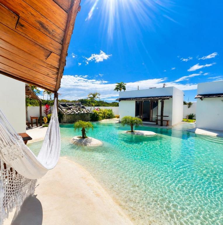 a swimming pool with a hammock in a resort at Anacardium in Canoa Quebrada